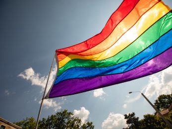 LGBTQIA+ flag. Concept photography of gay pride month at the street. Rainbow flags showing support for the LGBTQIA community with people at the LGBT event.